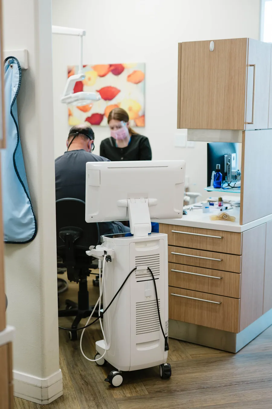 Dentist and dental assistant caring for a patient in a treatment room at CrossPointe Dental